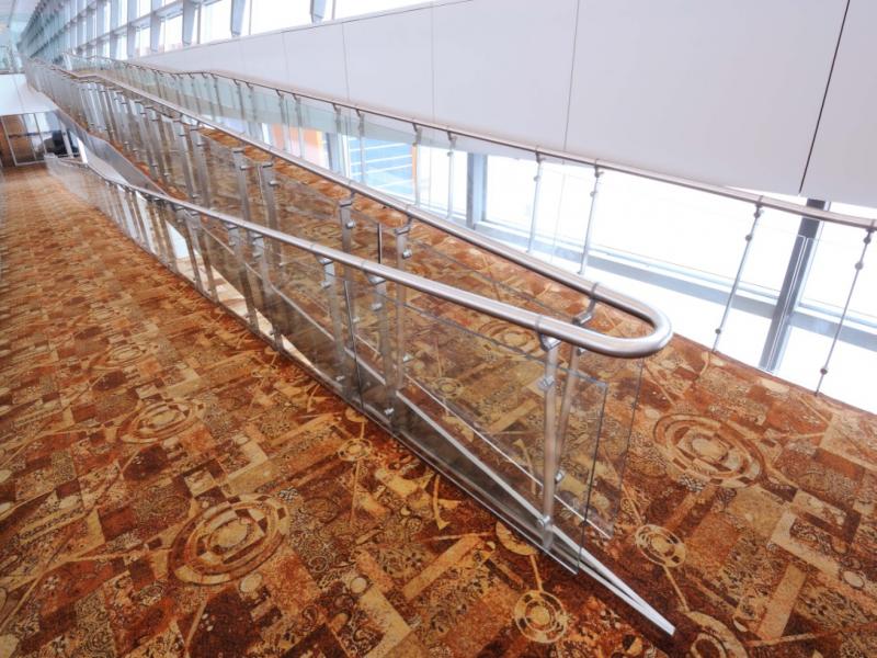 Stainless steel top Handrail connected with offset stems to stainless steel flat balustrade with ofset holders supporting 10mm glass.